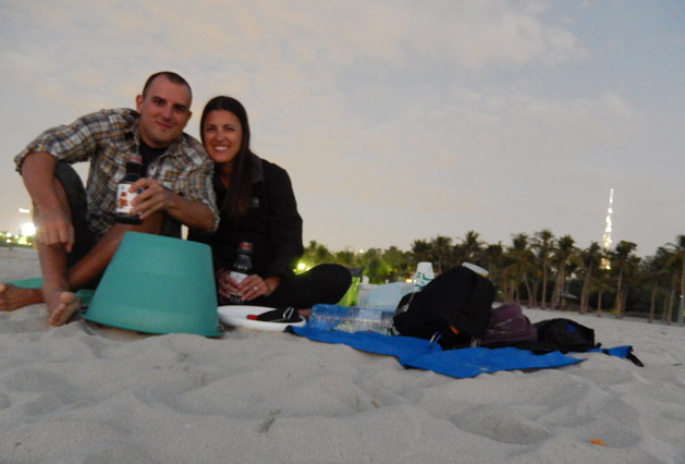 Picnic on the beach with wine in juice bottles.